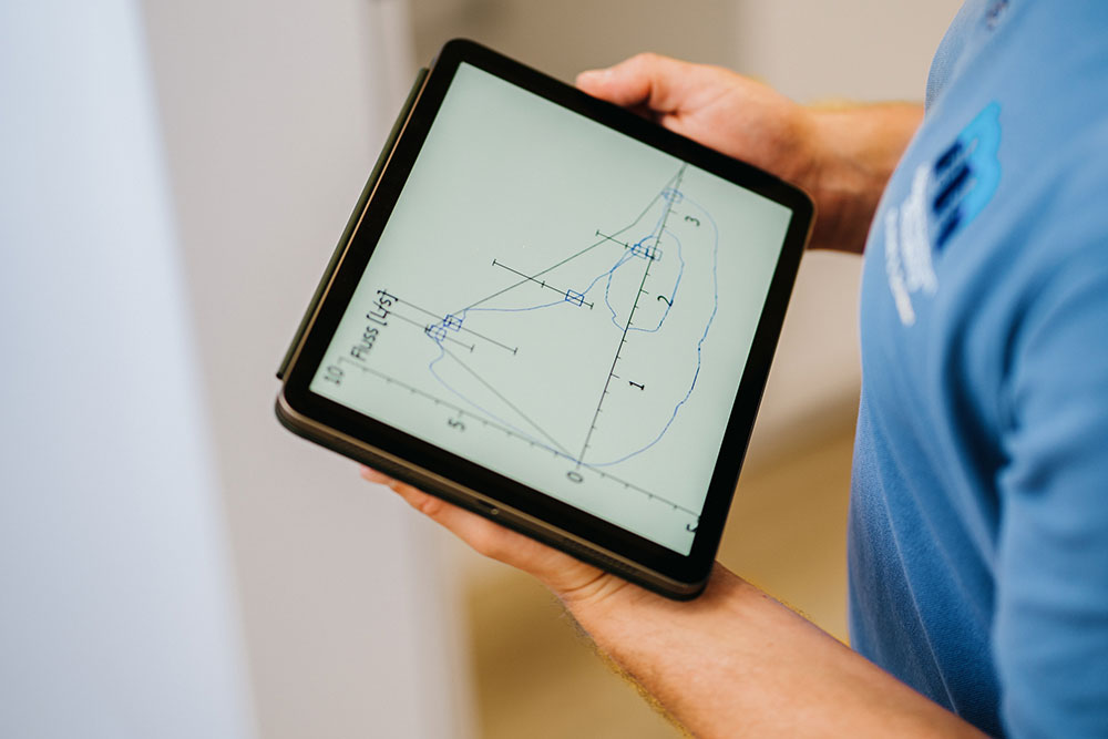 Hausarzt Schwabing – Dr. Mutschler – tauchtauglichkeit Arzt hält Tablet mit Grafik – Tauchtauglichkeitsuntersuchung beim Hausarzt München